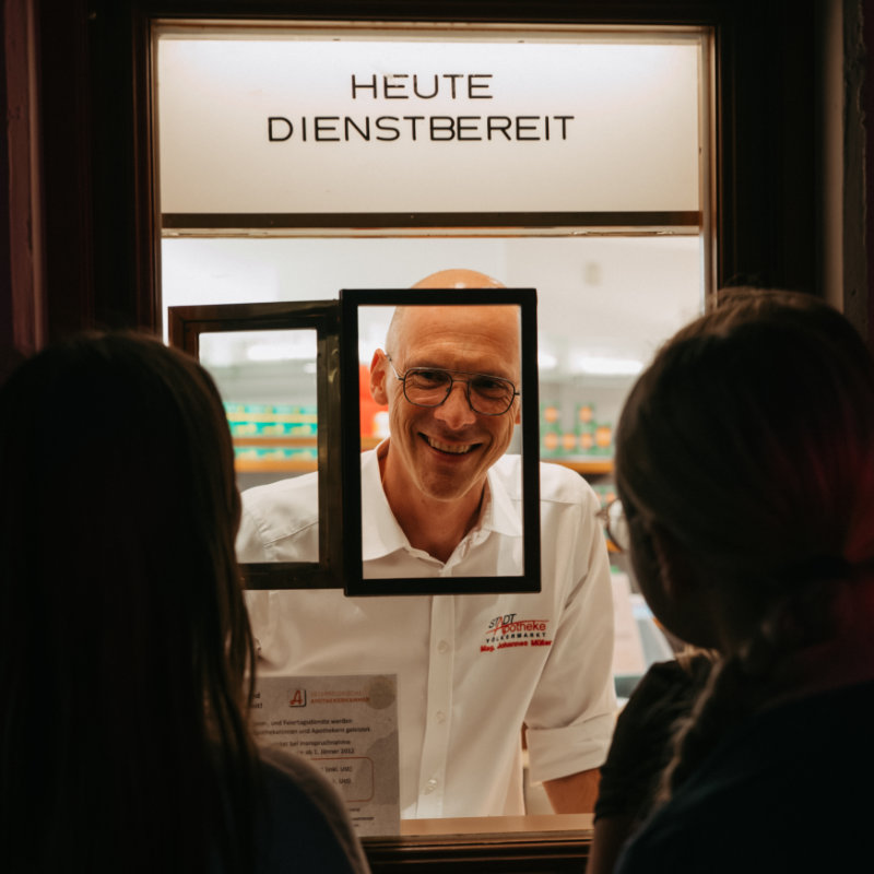 Apotheker schaut durch das Nachtdienst-Fenster